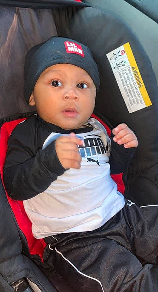 Kyree is registered to the contest to win money with this photo: baby, baby_products, baby_toddler_clothing, baseball_cap, black, cap, car_seat, carmine, cheek, child, comfort, elbow, finger, fun, headgear, headwear, person, personal_protective_equipment, pink, sitting