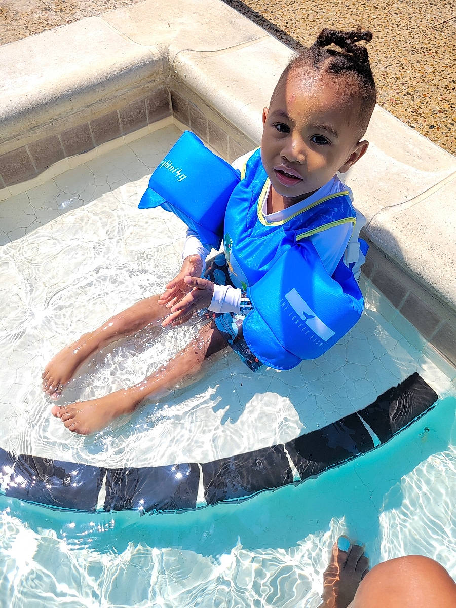 Bryce is registered to the contest to win money with this photo: aqua, azure, bathing, blue, boats_and_boating_equipment_and_supplies, child, electric_blue, fun, happy, leisure, person, personal_protective_equipment, play, product, recreation, shorts, sunglasses, swimming_pool, toddler, vacation