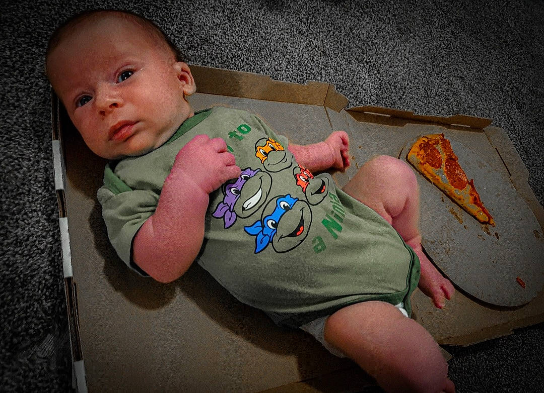 Grant is registered to the contest to win money with this photo: arm, baby, baby_products, baby_toddler_clothing, cheek, child, chin, finger, foot, hand, human_body, joint, leg, person, pink, sitting, skin, sleeve, t_shirt, thigh