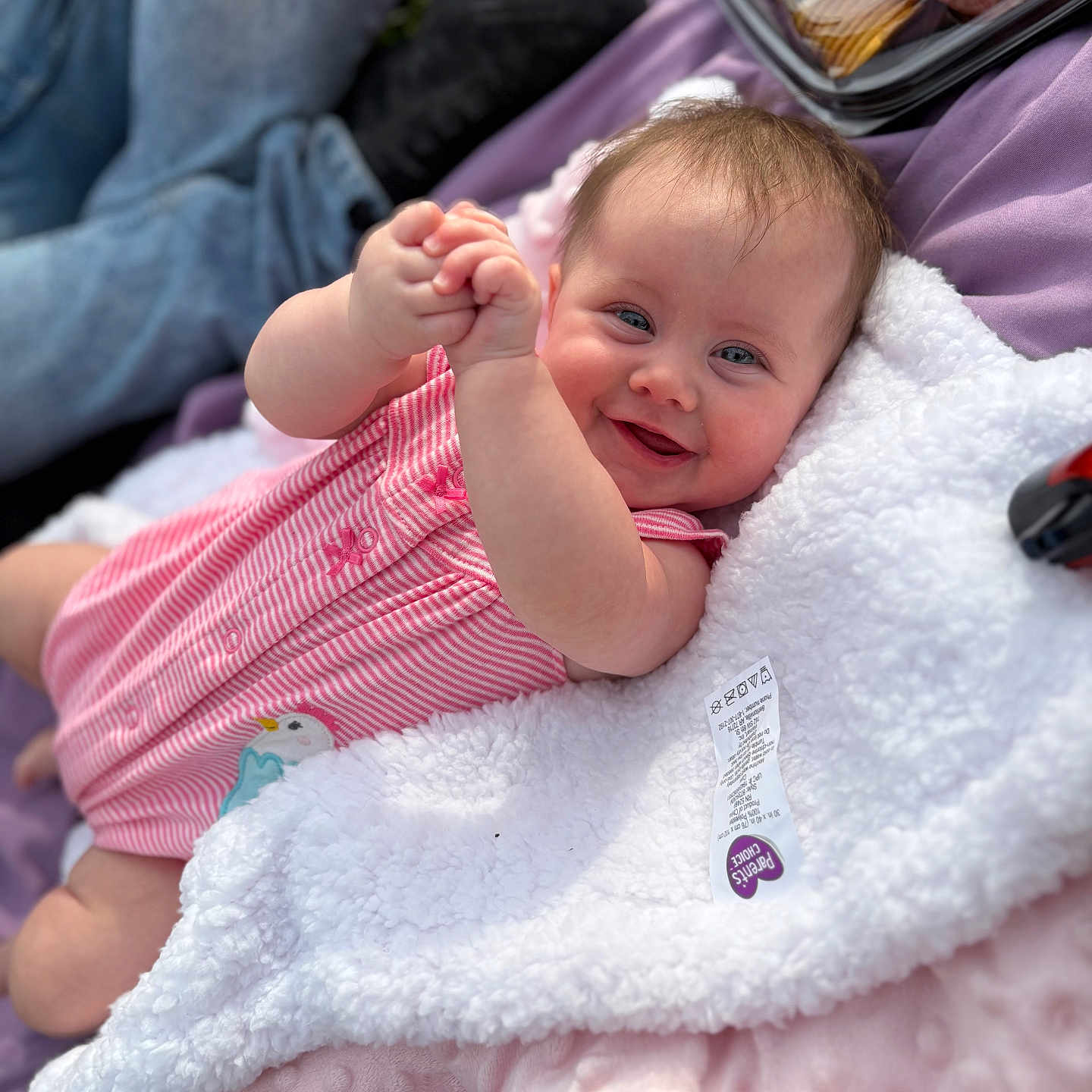 Kaleida Ka-Lie-da is registered to the contest to win money with this photo: baby, blanket, child, clapping_hands, cozy, cushion, cute, face, happy, head, infant, outdoor, person, pink_clothing, portrait, relaxed, skin, smiling, soft_texture, young