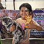 animal, background, banner, cat, child, clothing, colorful, cute, event, face_paint, fluffy_cat, girl, happy, holding, indoor, pet, portrait, short_sleeve_shirt, smiling, trophy