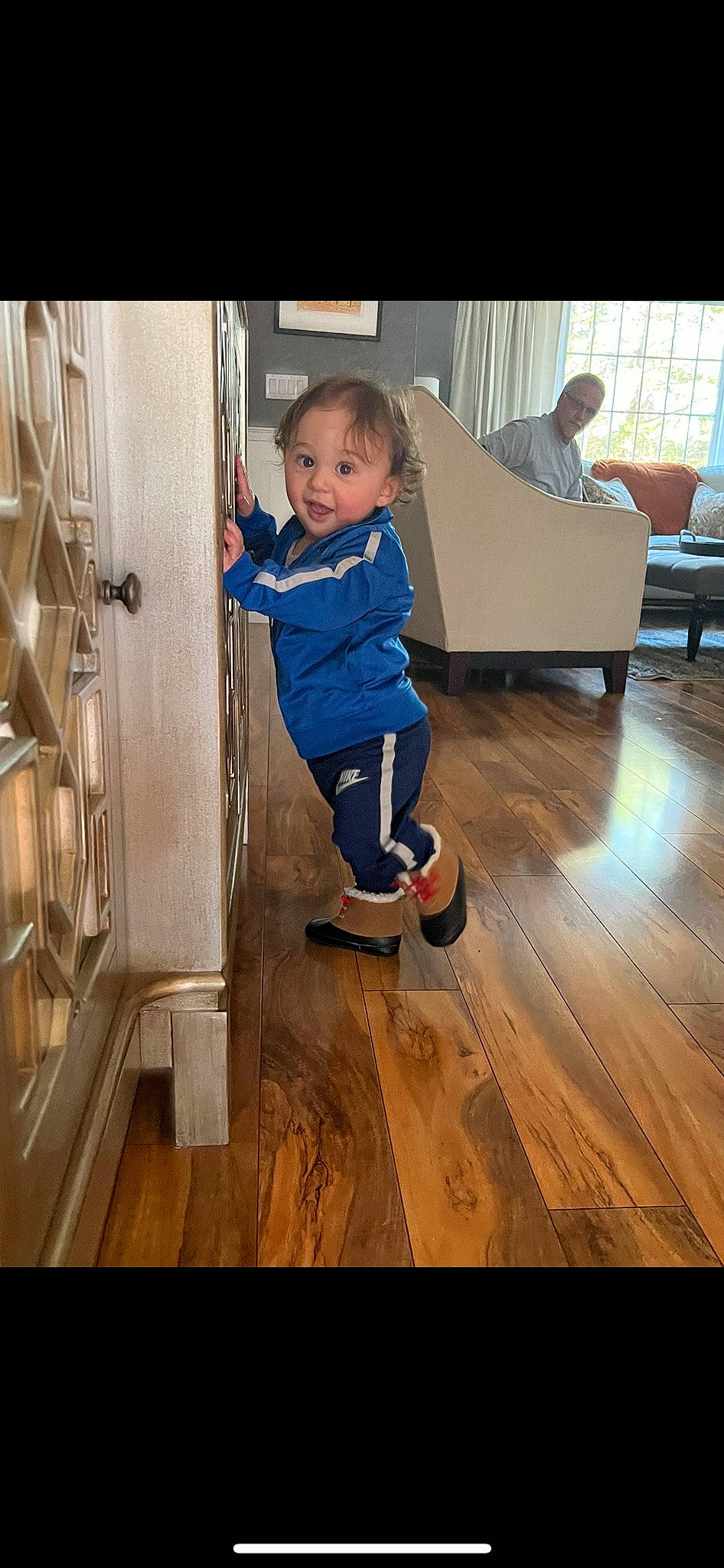 Evan is registered to the contest to win money with this photo: baby_toddler_clothing, chair, child, couch, door, floor, flooring, fun, happy, hardwood, laminate_flooring, leisure, person, play, sitting, smile, toddler, varnish, wood, wood_flooring