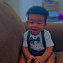 Josiah is registered to the contest to win money with this photo: toddler, child, smiling, bow_tie, suspenders, couch, indoor, hand, foot, happy, person, clothing, brown, furniture, hair, skin, room, box, flower, casual