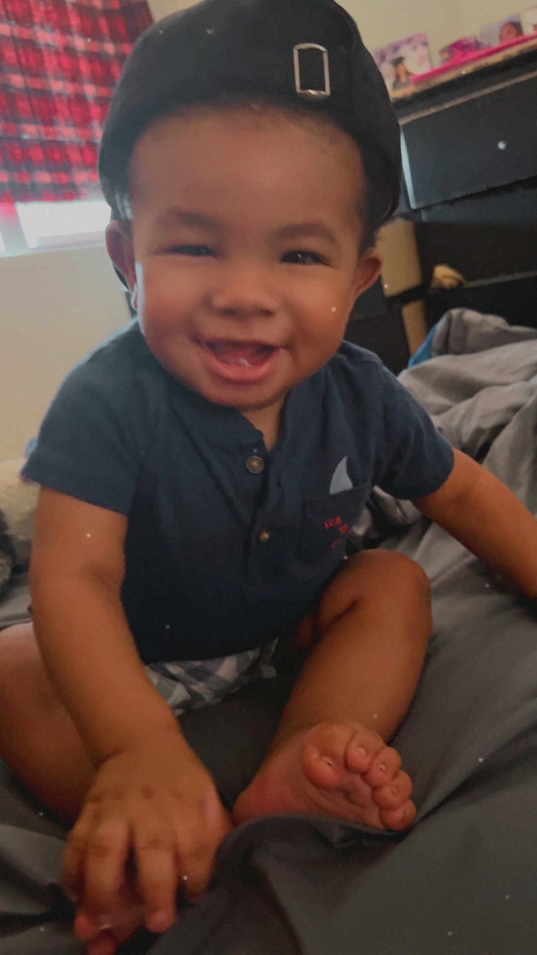 Josiah joined the competition — help win amazing prizes! toddler, child, smiling, cap, shirt, barefoot, bed, blanket, indoor, happy, cute, person, face, baby, casual_clothing, furniture, home, portrait, skin, sitting