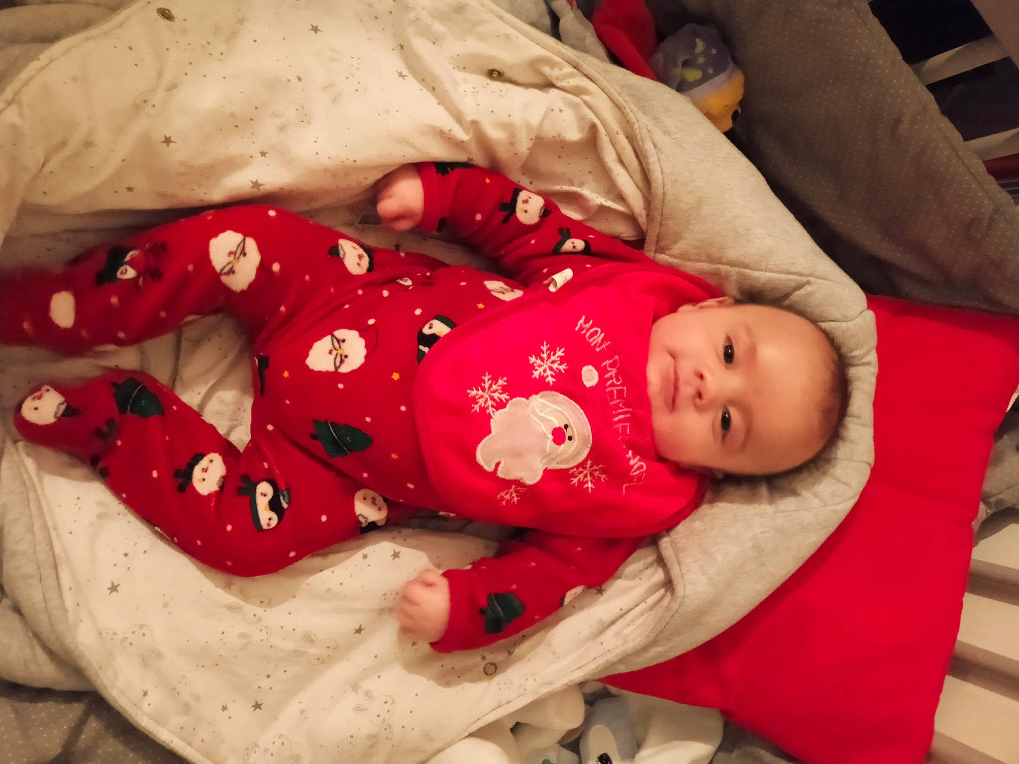 Arthur participe au concours pour gagner de l'argent avec cette photo : baby, baby_products, baby_toddler_clothing, carmine, child, comfort, facial_expression, flesh, happy, hat, head, linens, nightwear, pattern, person, product, room, sitting, sleeve, toddler