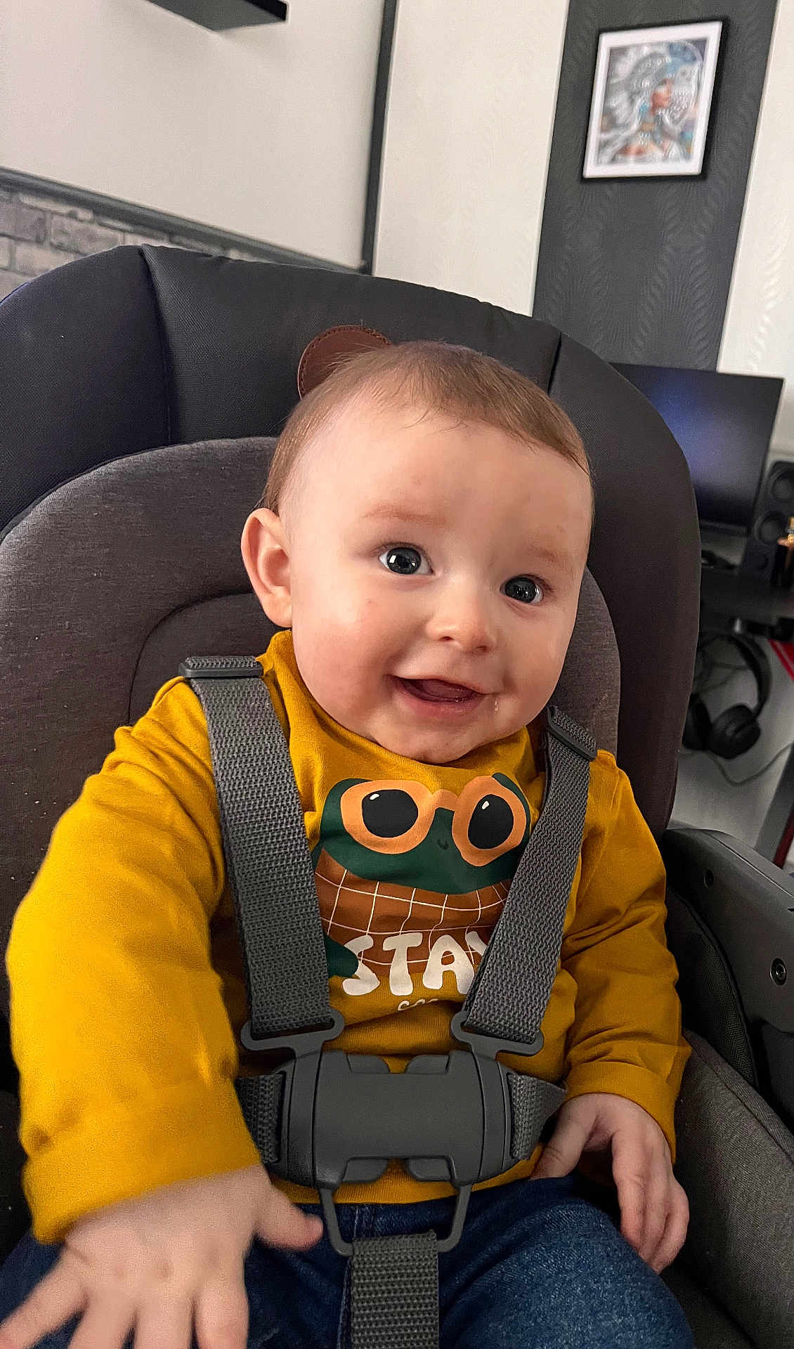 éthan a rejoint le concours — aidez-le/la à gagner de superbes lots ! baby, child, smiling, car_seat, seatbelt, yellow_shirt, frog_graphic, indoor, person, happy, toddler, clothing, hand, face, head, furniture, modern, portrait, cute, expression