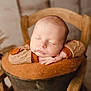 éthan a rejoint le concours — aidez-le/la à gagner de superbes lots ! baby, sleeping, infant, wooden_chair, cozy, brown, knitted_sweater, hands, face, peaceful, portrait, soft_lighting, indoors, furniture, resting, newborn, cute, warm_colors, child, relaxation