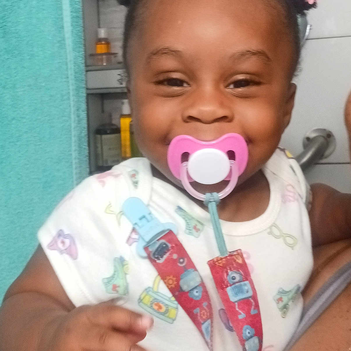 Sophia is registered to the contest to win money with this photo: accessories, baby, bodypart, clothing, cutlery, face, finger, hand, happy, head, indoors, jewelry, mouth, necklace, person, photography, portrait, spoon, t_shirt, teeth