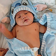 Timothy joined the competition — help win amazing prizes! baby, infant, blue_towel, hooded_towel, diaper, bed, white_sheets, cute, child, newborn, skin, sleepy, soft, cozy, blanket, person, hand, indoors, relaxed, towel