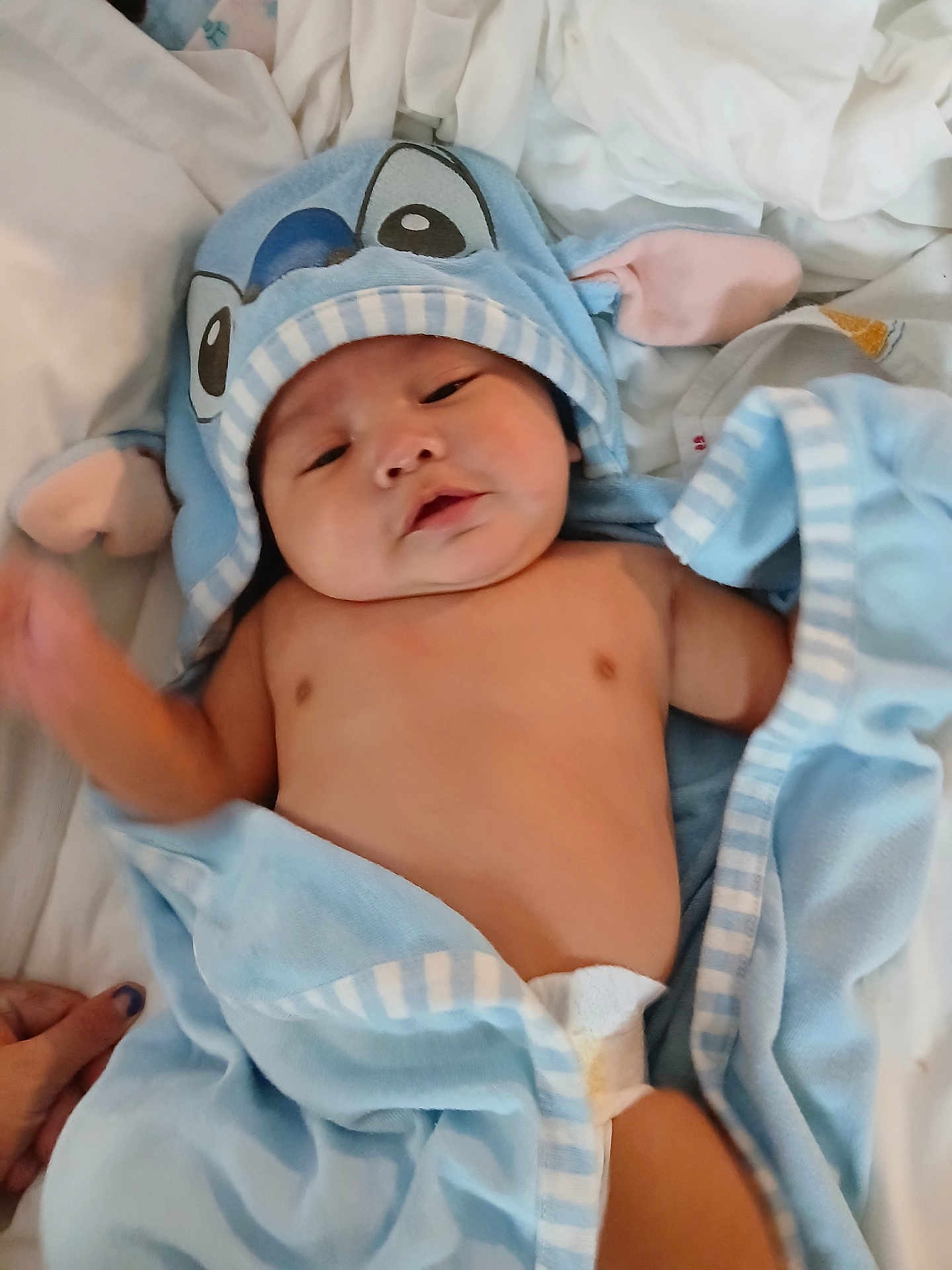 Timothy joined the competition — help win amazing prizes! baby, infant, blue_towel, hooded_towel, diaper, bed, white_sheets, cute, child, newborn, skin, sleepy, soft, cozy, blanket, person, hand, indoors, relaxed, towel