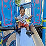 child, toddler, smiling, playground, slide, outdoor, summer, happy, person, clothing, shorts, shirt, sand, feet, sandals, metal, fun, play, sunlight, nature