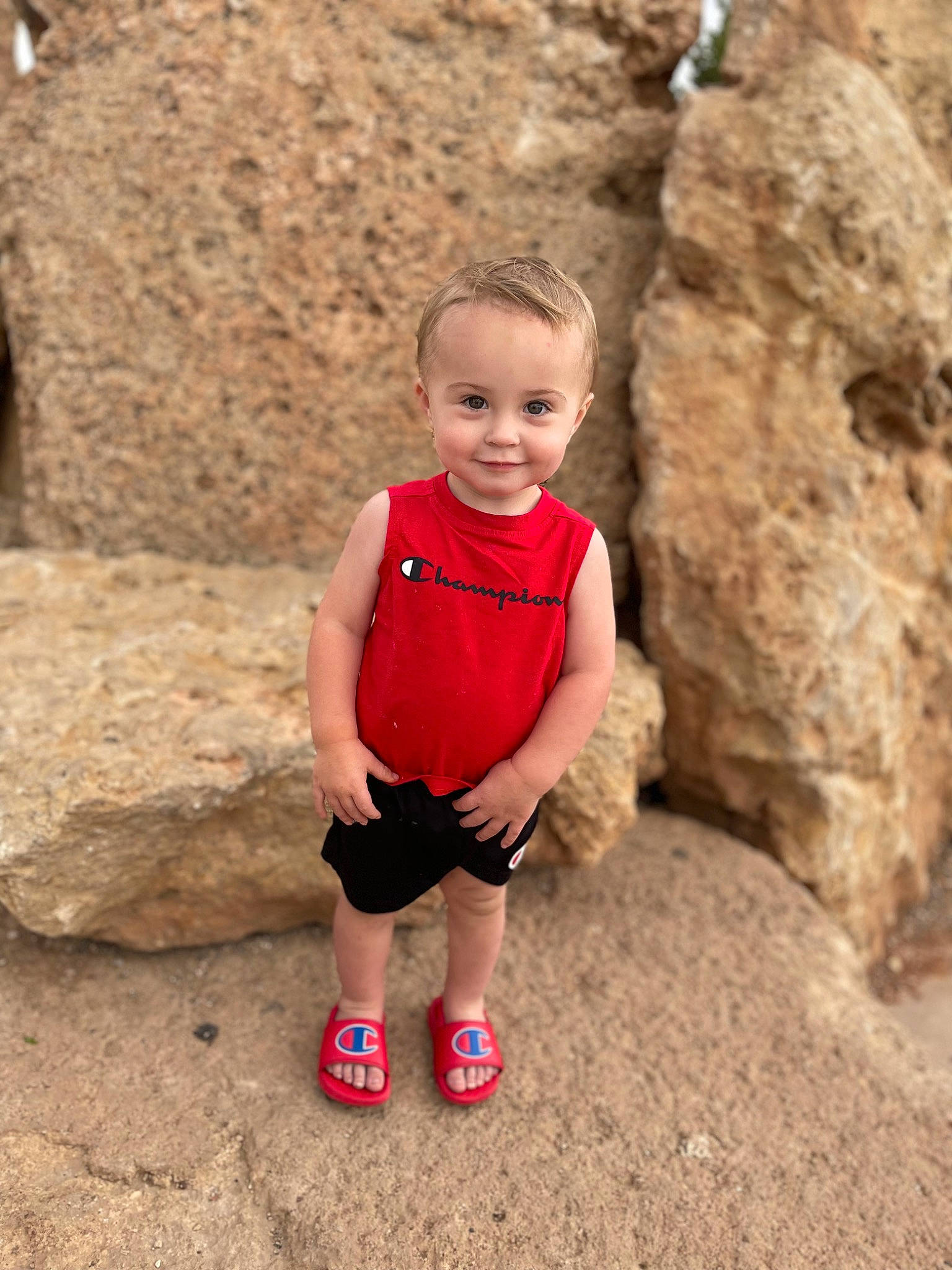Hayden is registered to the contest to win money with this photo: adventure, bedrock, child, face, fun, grass, happy, joy, landscape, leg, leisure, outcrop, people_in_nature, person, plant, recreation, shorts, smile, soil, toddler