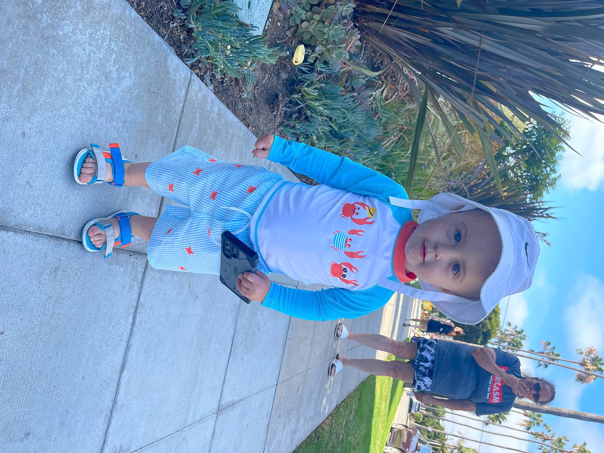 Hayden is registered to the contest to win money with this photo: azure, baby_toddler_clothing, blue, child, cloud, electric_blue, fun, grass, happy, hat, headwear, leisure, palm_tree, person, plant, sky, smile, t_shirt, toddler, tree