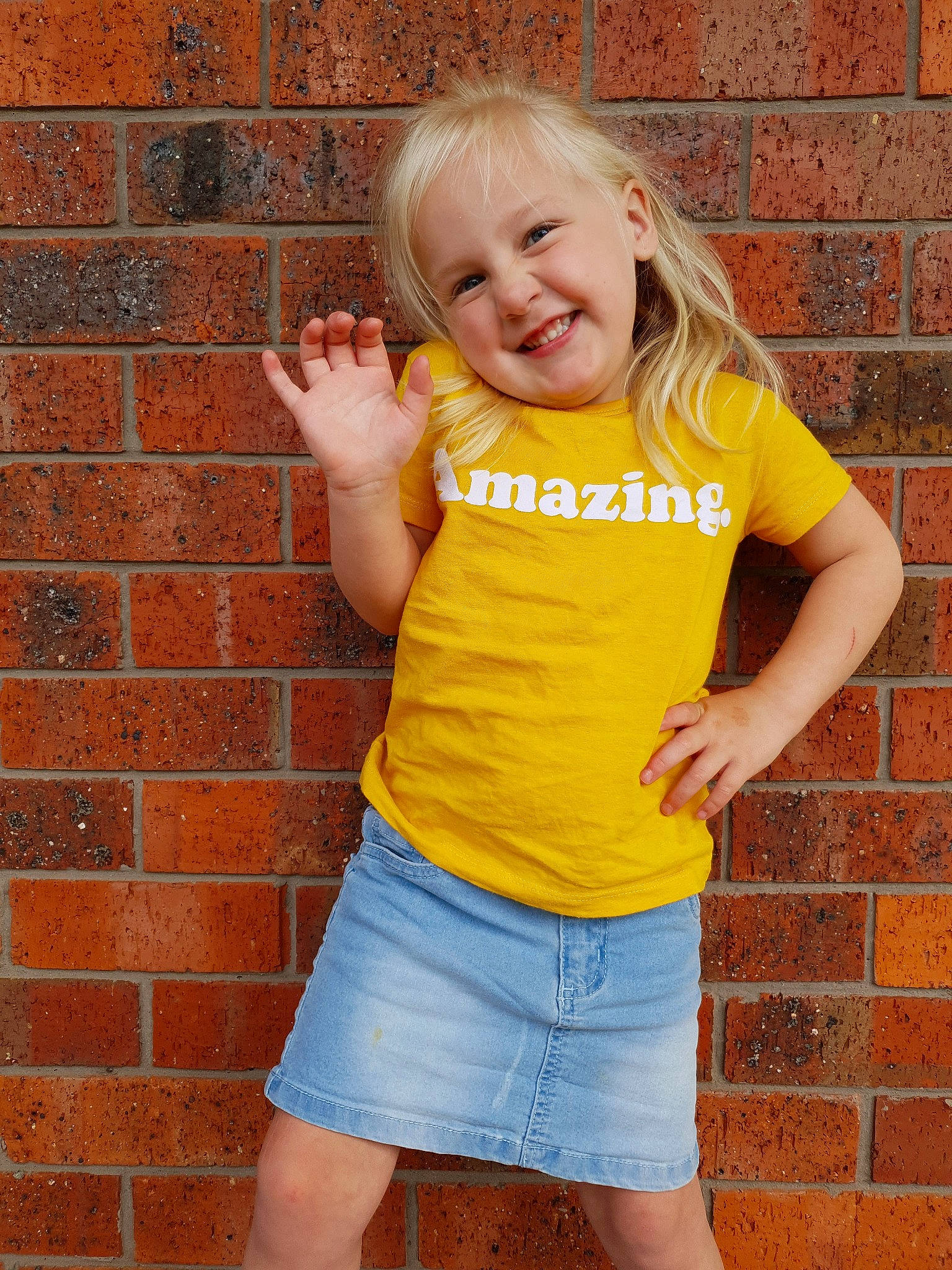 Lailah joined the competition — help win amazing prizes! blond, brick, child, child_model, denim, fun, jeans, joy, person, shorts, smile, t_shirt, toddler, wall, yellow