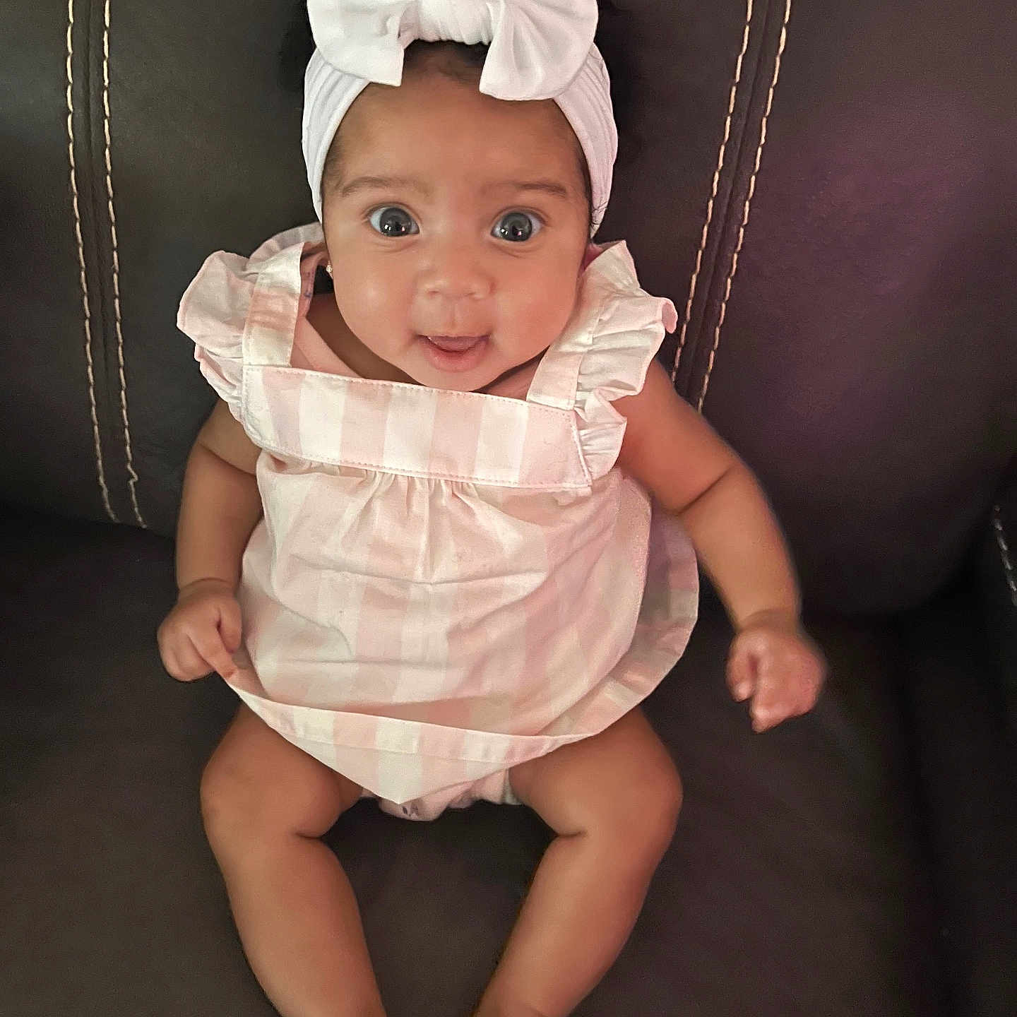 A'Kyla joined the competition — help win amazing prizes! baby, bow, child, clothing, couch, cute, happy, headband, indoors, infant, joyful, leather, person, pink_dress, portrait, sitting, smiling, striped, wide_eyes, young_child