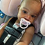 adorable, baby, black_straps, car, car_seat, child, child_safety, close_up, clothing, cute, eyes, face, headband, infant, pacifier, pink_bow, portrait, safety, seat_belt, straps