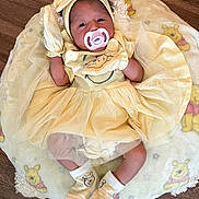 Eliana joined the competition — help win amazing prizes! baby, newborn, pacifier, yellow_dress, headband, mittens, socks, blanket, winnie_the_pooh, floor, wooden_floor, infant, cute, soft, lying_down, cozy, child, portrait, indoor, clothing