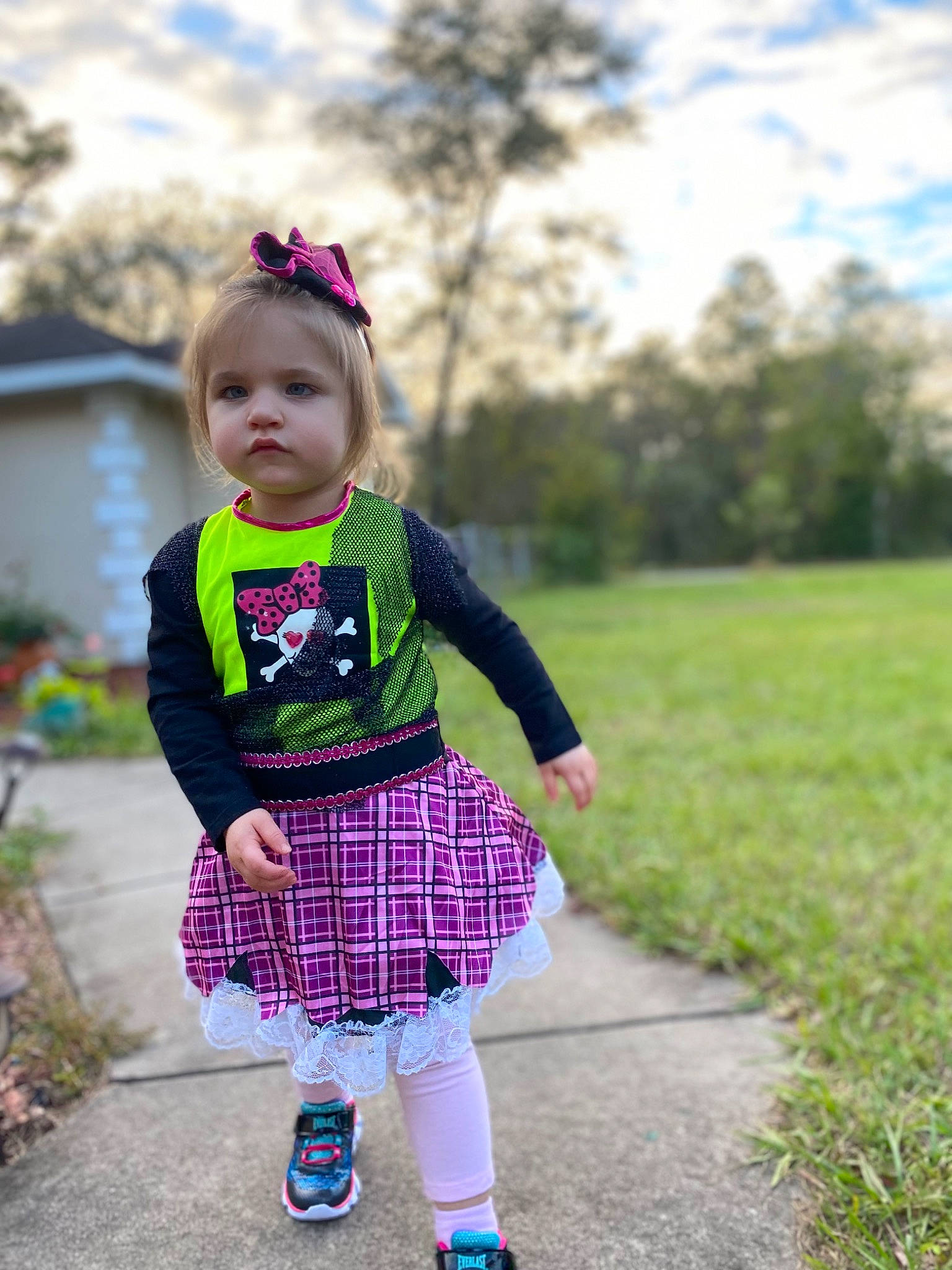 Ileanna is registered to the contest to win money with this photo: baby_toddler_clothing, child, face, footwear, grass, happy, magenta, pattern, person, pink, plaid, plant, purple, recreation, sky, sleeve, sock, summer, tartan, toddler