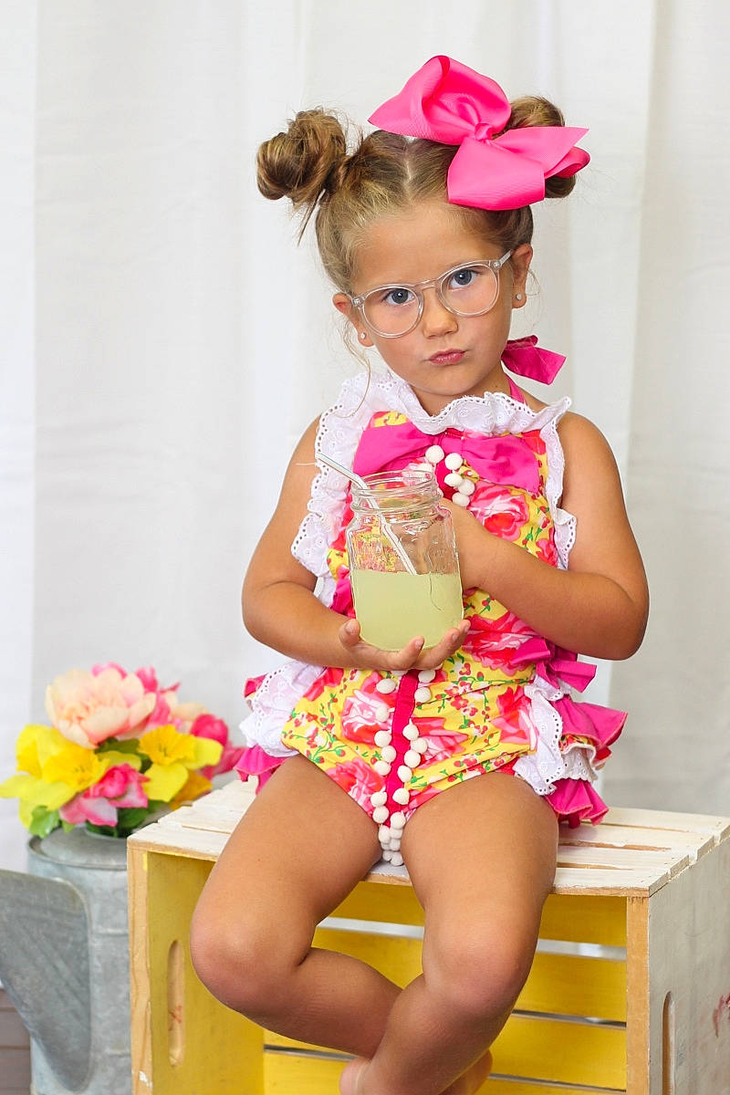 Jillian joined the competition — help win amazing prizes! baby_toddler_clothing, child, child_model, clothing, costume, fashion_accessory, hair_accessory, headband, headpiece, leg, pattern, person, petal, pink, ruffle, sitting, thigh, toddler, yellow