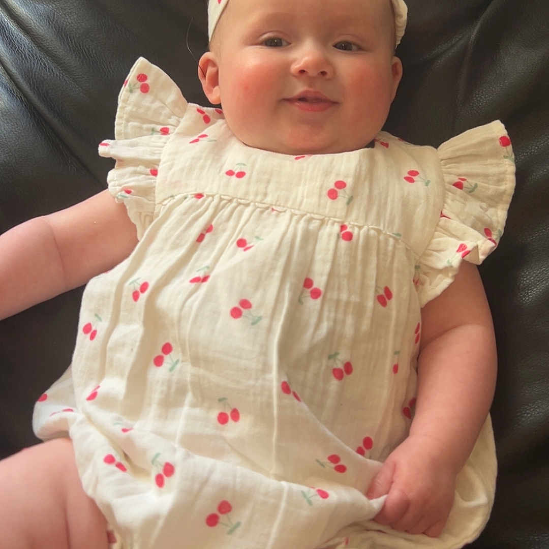 Melody joined the competition — help win amazing prizes! baby, cherry_pattern, child, comfortable, couch, cute, face, hand, head, headband, indoor, infant, leather, plump, portrait, relaxed, sitting, skin, smiling, white_clothing