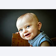 Marceau a rejoint le concours — aidez-le/la à gagner de superbes lots ! baby, child, smiling, face, blue_eyes, wooden_chair, portrait, cute, infant, happy, closeup, indoor, soft_light, background_blur, person, skin, head, clothing, sleeveless, young