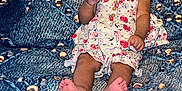 Arielle is registered to the contest to win money with this photo: baby, barefoot, blue_pattern, child, couch, cute, expression, floral_dress, furniture, girl, happy, head, indoors, infant, person, portrait, red_bow, seated, skin, smiling