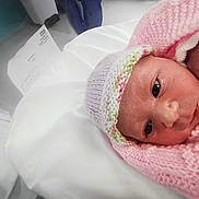 Thea-Rose is registered to the contest to win money with this photo: newborn, baby, infant, hospital, blanket, knitted_hat, maternity, bed, cot, face, person, closeup, pink, white, sleeping, resting, child, healthcare, soft, wrapped
