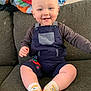 George joined the competition — help win amazing prizes! baby, child, smiling, cute, sitting, couch, overalls, socks, indoor, happy, face, person, infant, clothing, blanket, toy, home, colorful, comfort, portrait