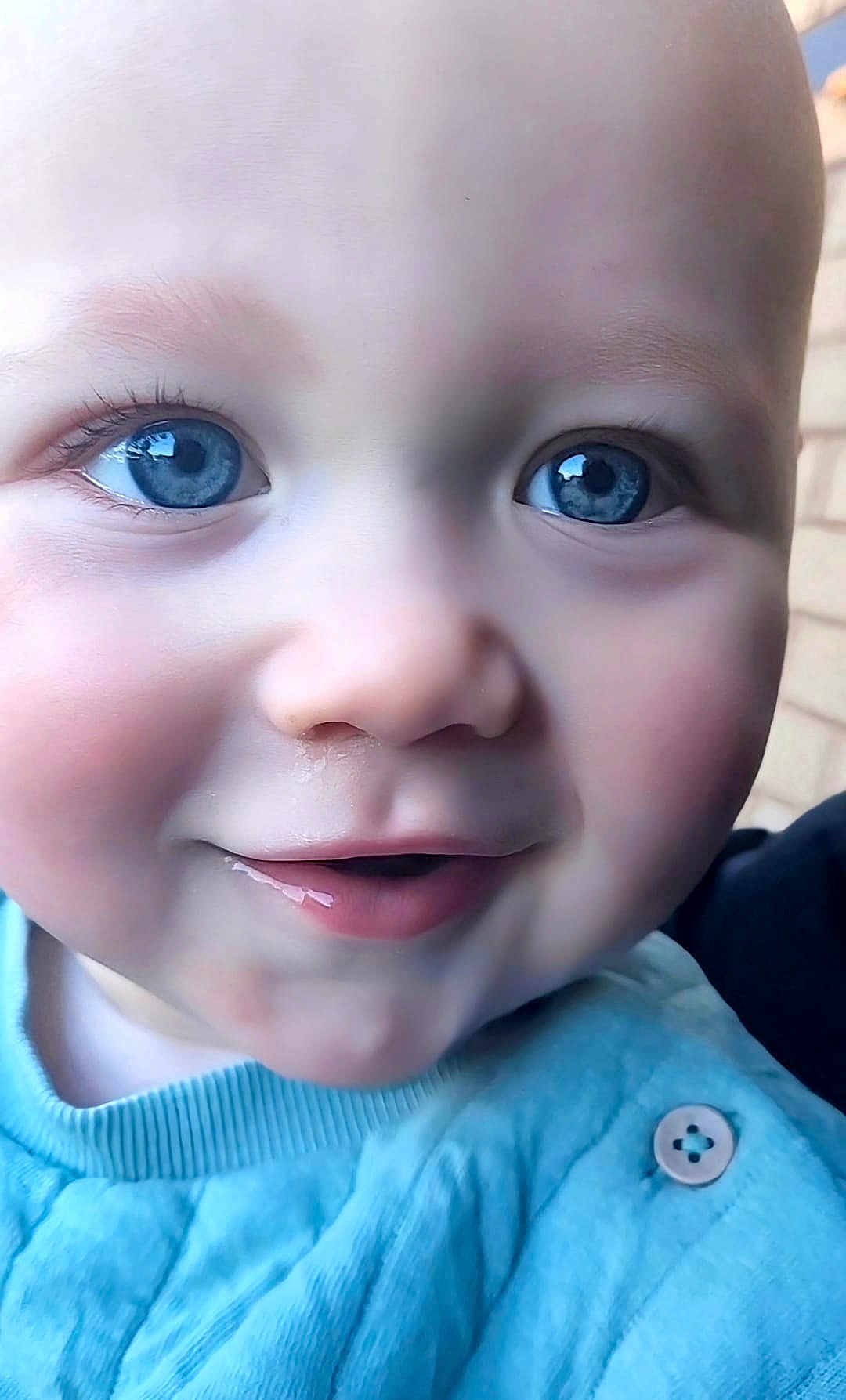 George joined the competition — help win amazing prizes! baby, close_up, face, blue_eyes, smile, drool, skin, clothing, button, child, infant, cute, portrait, young, head, expression, baby_clothes, person, cheeks, eyelashes