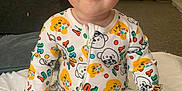 George joined the competition — help win amazing prizes! baby, child, smiling, onesie, colorful_clothing, indoor, couch, toys, blanket, sitting, face, blue_eyes, happy, infant, cute, playful, person, carpet, room, childhood