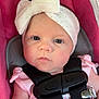 Riley is registered to the contest to win money with this photo: baby, child, infant, headband, bow, car_seat, harness, pink, clothing, face, skin, hand, cute, portrait, sitting, young, person, closeup, seatbelt, safety