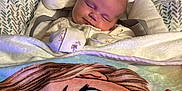 Riley is registered to the contest to win money with this photo: baby, sleeping, blanket, baby_seat, cartoon, pacifier, cozy, infant, face, soft, cushion, clothing, indoors, child, cute, resting, young, comfort, portrait, peaceful