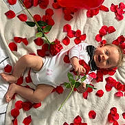 Isaak participe au concours pour gagner de l'argent avec cette photo : baby, infant, smiling, rose, rose_petals, balloon, heart_balloon, blanket, bow_tie, onesie, lipstick_mark, printed_photo, portrait, lying_down, playful, red_color, white_blanket, hands, feet, scattered_petals