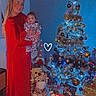 Isaak participe au concours pour gagner de l'argent avec cette photo : baby, celebration, chair, christmas_tree, decorations, family, festive_pajamas, floor, gift_wrap, giraffe_toy, heart_doodle, holiday, indoor, lights, ornaments, presents, red_dress, smile, woman, wooden_floor