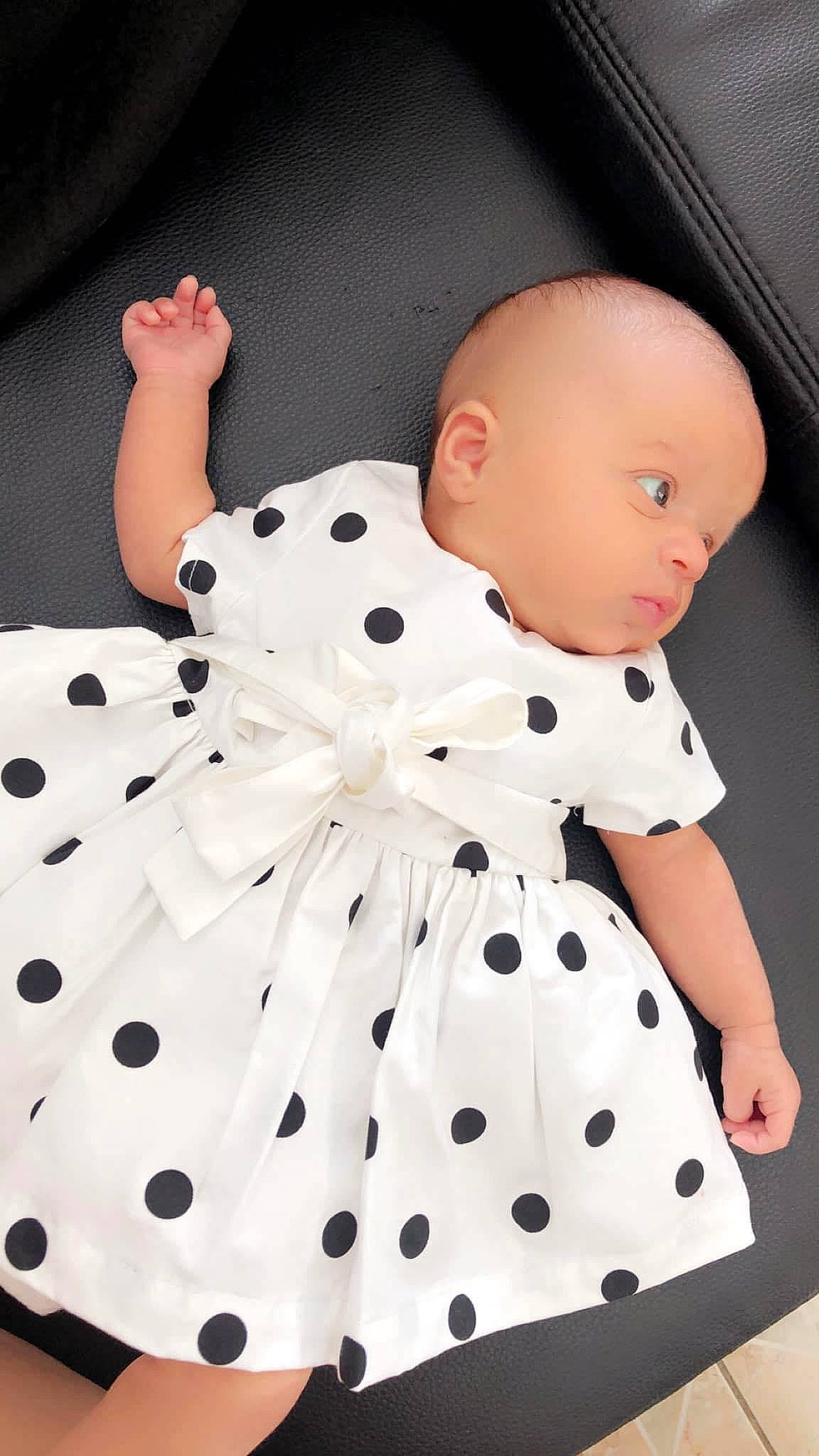Leyana participe au concours pour gagner de l'argent avec cette photo : arm, baby, baby_products, baby_toddler_clothing, black, child, collar, day_dress, design, dress, human_body, one_piece_garment, pattern, person, photograph, pink, product, sleeve, textile, toddler
