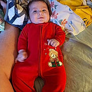 Dustin Lee Willis Jr joined the competition — help win amazing prizes! baby, infant, red_onesie, teddy_bear, bed, blanket, pillow, person, sleepwear, cute, lying_down, child, indoors, soft_fabric, comfort, relaxing, human, newborn, smiling, cozy