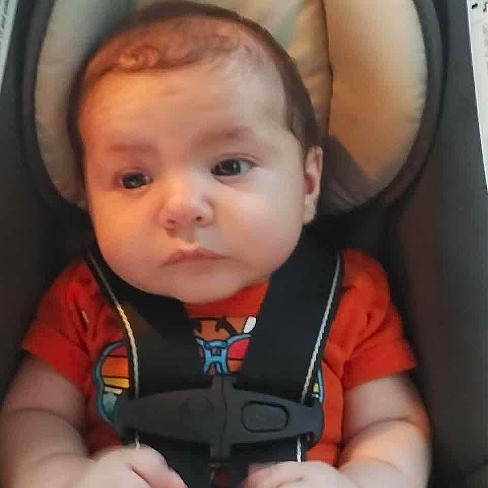Dustin Lee Willis Jr is registered to the contest to win money with this photo: baby, car, car_seat, child, child_safety, chubby_cheeks, cute, expression, face, hands, head, indoor, infant, orange_shirt, person, portrait, safety_harness, seat, straps, young_child