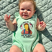 Luca is registered to the contest to win money with this photo: baby, child, infant, onesie, quilted_blanket, outdoor, grass, sunlight, happy, smiling, face, skin, hair, arms, legs, clothing, cute, portrait, lying_down, daylight