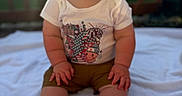 Luca is registered to the contest to win money with this photo: baby, child, smiling, outdoor, blanket, sunlight, fence, happy, sitting, toddler, clothing, shorts, shirt, feet, face, portrait, grass, daylight, skin, cute