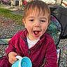 toddler, child, smiling, maroon_jumpsuit, blue_cup, camping_chair, outdoor, daylight, gravel, trees, camper, recreational_vehicle, happy, person, young_child, nature, playful, seat, casual, fun