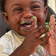 Amias Williams joined the competition — help win amazing prizes! toddler, child, smiling, happy, face, hands, cake, crumbs, messy, clapping, celebration, food, cute, closeup, indoor, person, curly_hair, white_shirt, joy, playful
