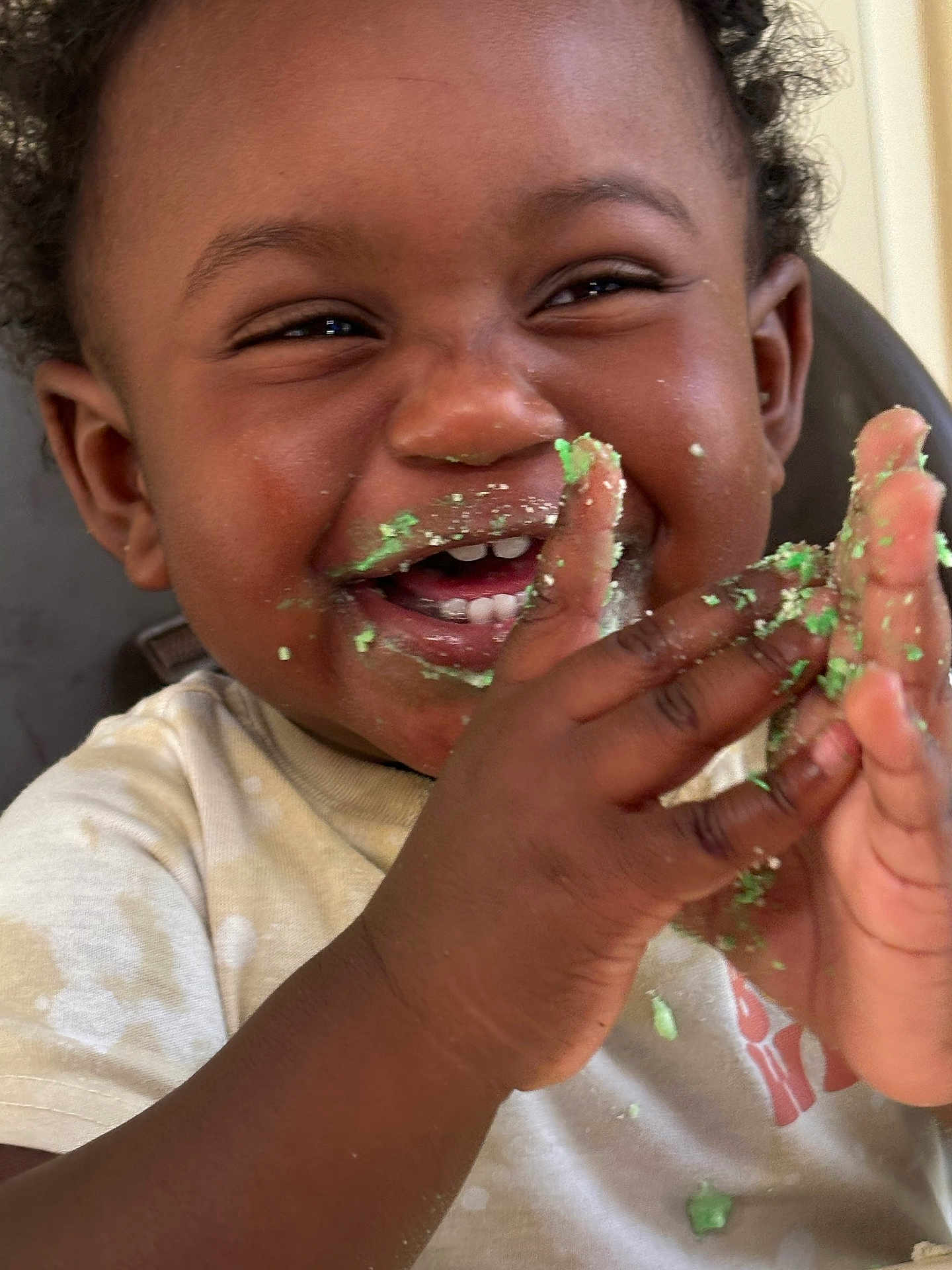 Amias Williams joined the competition — help win amazing prizes! toddler, child, smiling, happy, face, hands, cake, crumbs, messy, clapping, celebration, food, cute, closeup, indoor, person, curly_hair, white_shirt, joy, playful
