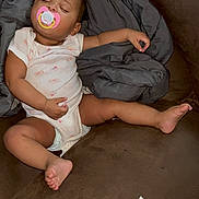 Caliyah is registered to the contest to win money with this photo: baby, sleeping, pacifier, blanket, couch, diaper, infant, child, relaxing, indoors, comfort, clothing, person, furniture, rest, cute, nap, peaceful, skin, home