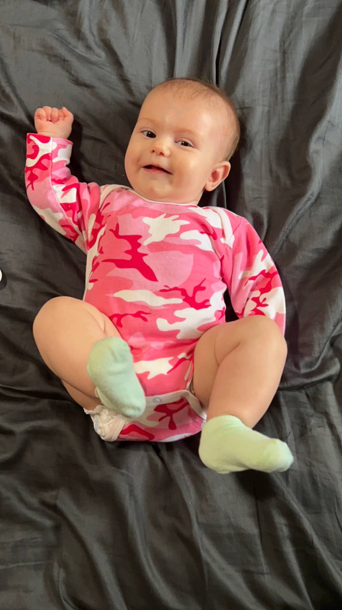 Mavis is registered to the contest to win money with this photo: baby, baby_toddler_clothing, cheek, child, comfort, elbow, eye, face, flash_photography, gesture, happy, human_body, magenta, person, pink, shoulder, skin, sleeve, smile, stomach