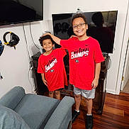 Kyan And Bo joined the competition — help win amazing prizes! child, smiling, indoor, red_shirt, glasses, television, headphones, wood_floor, furniture, chair, happy, person, sibling, shorts, black_shoes, technology, cable, console, playful, curly_hair