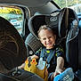 toddler, child, car_seat, smile, sock, crown, car_interior, seatbelt, window, daylight, happy, curly_hair, clothing, safety, playful, portrait, automobile, young_child, seat, person