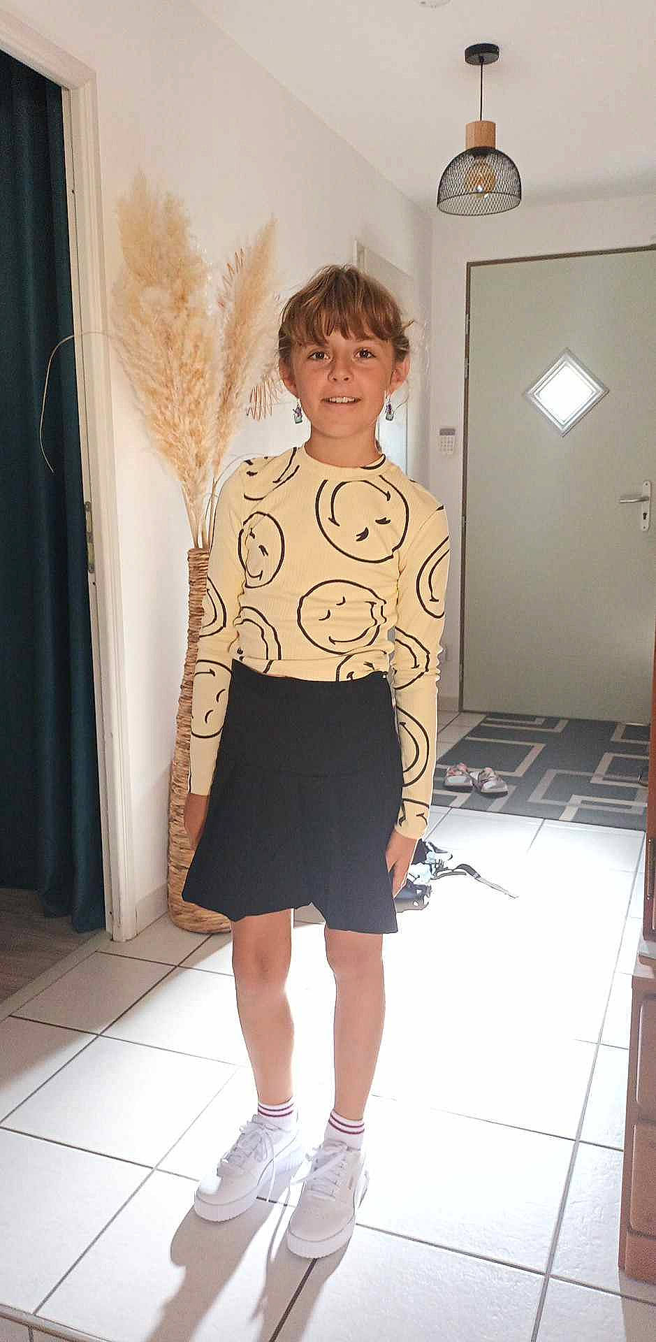 Chloe participe au concours pour gagner de l'argent avec cette photo : arm, art, curtain, door, eyewear, fashion_design, flooring, human_body, human_leg, joy, knee, neck, pattern, person, room, sleeve, smile, standing, t_shirt, thigh