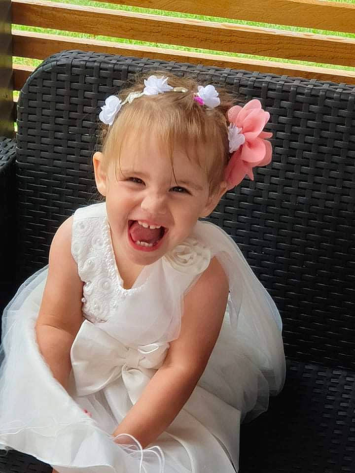 Maëline a rejoint le concours — aidez-le/la à gagner de superbes lots ! baby_toddler_clothing, blond, bridal_accessory, child, dress, embellishment, event, fashion_accessory, flash_photography, hair_accessory, happy, headband, headpiece, iris, jewellery, person, petal, pink, skin, smile