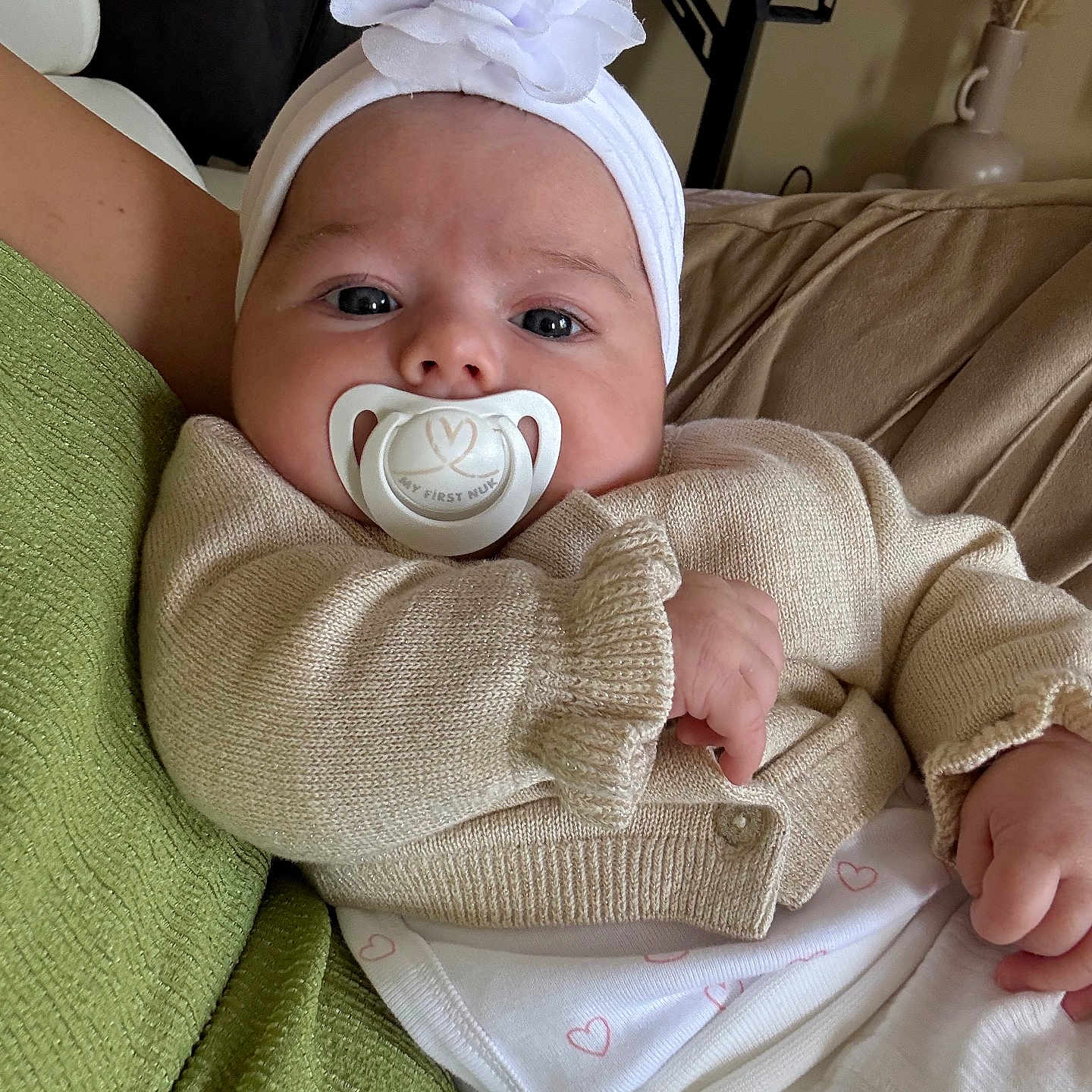 Alma a rejoint le concours — aidez-le/la à gagner de superbes lots ! baby, blanket, child, closeup, couch, cute, flower, green_blanket, headband, heart_pattern, indoor, infant, knitwear, pacifier, person, portrait, resting, soft_lighting, sweater, white_clothing