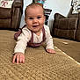 baby, brown_chair, carpet, carpet_texture, cheeky, child, clothing, cozy, crawling, face, hand, holiday_decor, indoors, lamp, living_room, overalls, person, smile, table, white_shirt